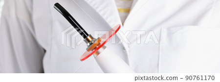 Dentist doctor in gloves hold special tool for teeth whitening 90761170