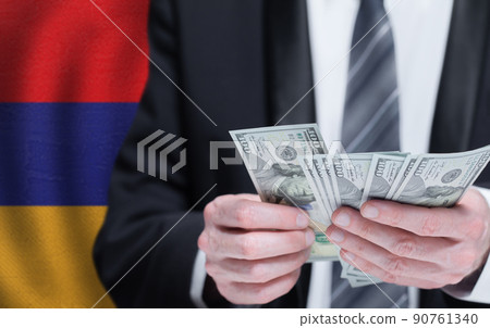 Hands holding dollar money on flag of Armenia Hands holding dollar money on flag of Armenia 90761340