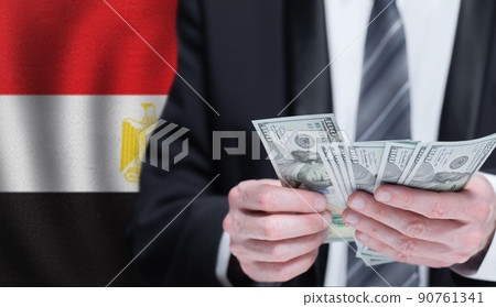 Hands holding dollar money on flag of Egypt Hands holding dollar money on flag of Egypt 90761341