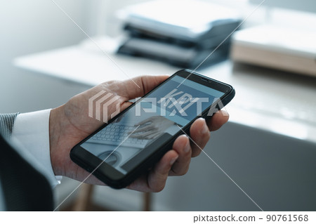 text KPI in the screen of his smartphone text KPI in the screen of his smartphone 90761568