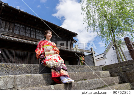 A kimono woman sitting on a stone staircase and taking a break A kimono woman sitting on a stone staircase and taking a break 90762895