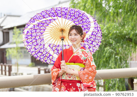 A woman in kimono holding a Japanese umbrella A woman in kimono holding a Japanese umbrella 90762953