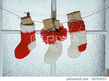 socks for christmas gifts hanging on the window 90763655