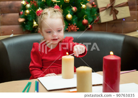 A small child sits at the New Year's festive table A small child sits at the New Year's festive table 90763835