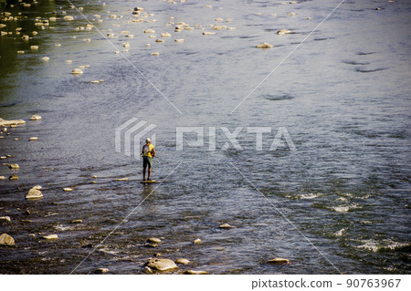 a fisherman on the stone in the middle of Opir river, Skole Beskids National Nature Park, Ukraine a fisherman on the stone in the middle of Opir river, Skole Beskids National Nature Park, Ukraine 90763967