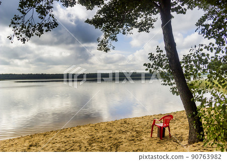 red chear on lake beach red chear on lake beach 90763982