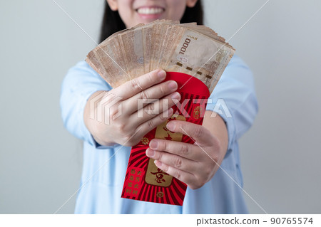 Asian women are glad to receive a lot of extra money from red envelopes. Asian women are glad to receive a lot of extra money from red envelopes. 90765574
