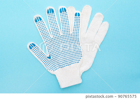 Protective construction gloves in white on a blue background. Flat lay. Top view. 90765575