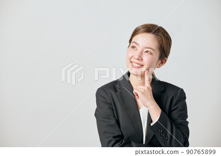 A young woman in a jacket thinking 90765899
