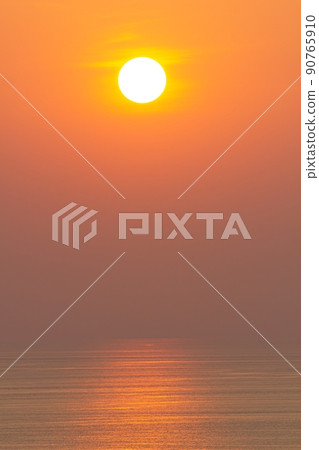 Sunset, the sea surface, reflecting the sun in orange. Clear sky, cloudless orange 90765910