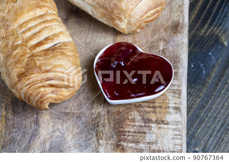 puff pastry with red strawberry jam on a wooden table puff pastry with red strawberry jam on a wooden table 90767364