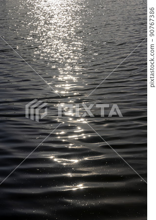 glare from sunlight on the surface of the lake water glare from sunlight on the surface of the lake water 90767386