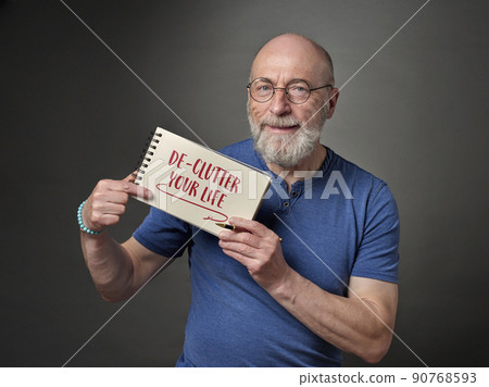 declutter your life - senior man with notebook sign 90768593