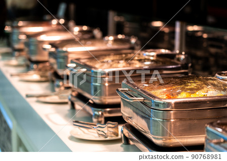 Catering buffet food with heated trays ready for service in hotel restaurant Catering buffet food with heated trays ready for service in hotel restaurant 90768981