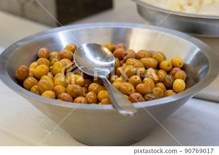 Closeup of marinated green olives in bowl on table Closeup of marinated green olives in bowl on table 90769017