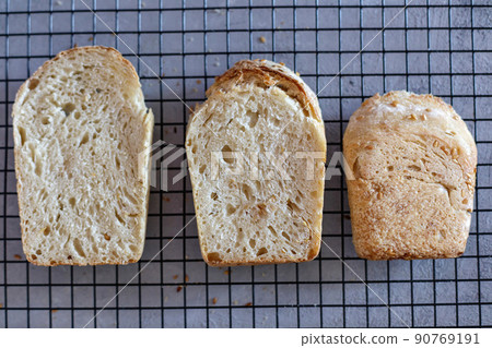Baked Ruddy Wheat Bread Brick on sourdough with flax seeds on a black grid, on gray concrete background. Baked Ruddy Wheat Bread Brick on sourdough with flax seeds on a black grid, on gray concrete background. 90769191