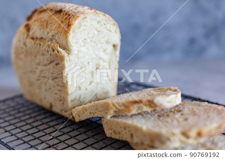 Baked Ruddy Wheat Bread Brick on sourdough with flax seeds on a black grid, on gray concrete background. Baked Ruddy Wheat Bread Brick on sourdough with flax seeds on a black grid, on gray concrete background. 90769192