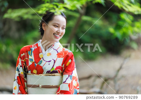 A young woman wearing a kimono and sightseeing in Kyoto 90769289