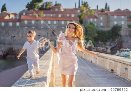 Mother and son tourists on background of beautiful view St. Stephen island, Sveti Stefan on the Budva Riviera, Budva, Montenegro. Travel to Montenegro concept 90769522