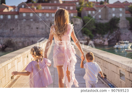 Mother and two children daughter and son tourists on background of beautiful view St. Stephen island, Sveti Stefan on the Budva Riviera, Budva, Montenegro. Travel to Montenegro concept Mother and two children daughter and son tourists on background of beautiful view St. Stephen island, Sveti Stefan on the Budva Riviera, Budva, Montenegro. Travel to Montenegro concept 90769523