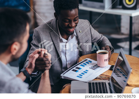 Two Businessmen Having Meeting Around Table In Cafe. Two Businessmen Having Meeting Around Table In Cafe. 90769870