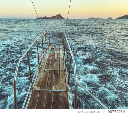 bridge made of wood with metal breaks into the sea. water with white foam, blue waves. bridge on a yacht for bathing tourists, jumping into the water from a height bridge made of wood with metal breaks into the sea. water with white foam, blue waves. bridge on a yacht for bathing tourists, jumping into the water from a height 90770034