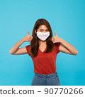 Asian woman wear face mask, thumbs up. Isolate on blue color background 90770266