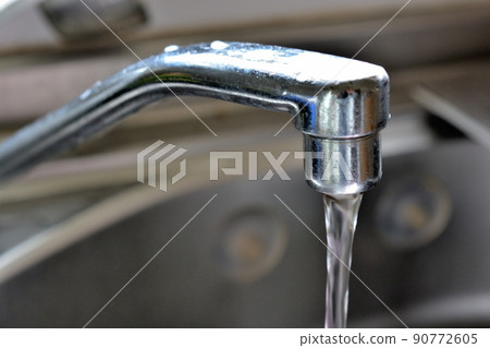 Kitchen water supply with water coming out of the faucet 90772605