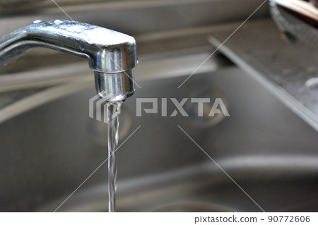 Kitchen water supply with water coming out of the faucet 90772606