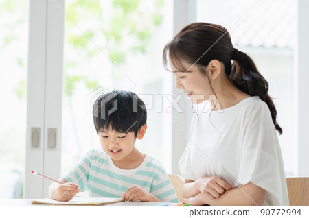Boy and mother studying in the living room 90772994
