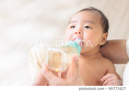Baby holding a baby bottle 1 month old Copy space Baby holding a baby bottle 1 month old Copy space 90773827