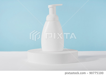 Bath soap white cosmetic bottle mockup on white podium pedestal on blue background. Body care foam product or lotion packaging. Plastic cosmetics tube front view mock up. Bath soap white cosmetic bottle mockup on white podium pedestal on blue background. Body care foam product or lotion packaging. Plastic cosmetics tube front view mock up. 90775100