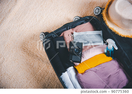 Open suitcase with traveler belongings clothes and accessories of things ready packing to be taken on summer holiday 90775360