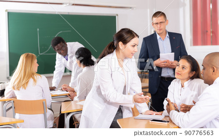 Adult people in white coats working in groups during professional training 90776563