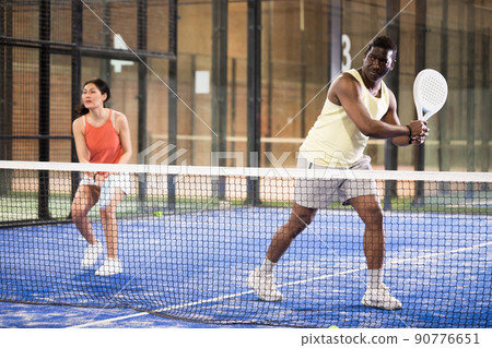 Team of padel players man and woman playing doubles Team of padel players man and woman playing doubles 90776651
