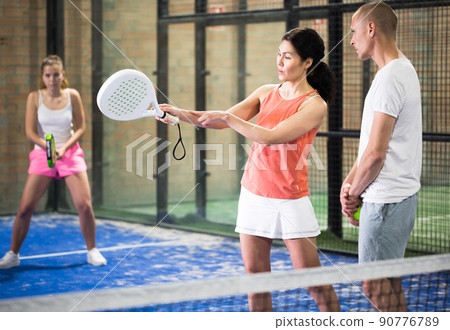 Portrait of concentrated trainer teaching young player Portrait of concentrated trainer teaching young player 90776789