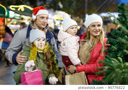 Happy family choosing Christmas tree 90776822
