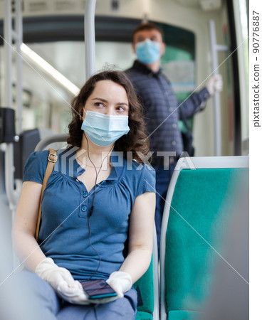 Portrait of female passenger in personal protective equipment in tram Portrait of female passenger in personal protective equipment in tram 90776887