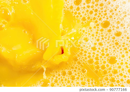 Closeup of splashing orange juice, top view. Splash of fresh sweet orange, mango, fruit juice. Closeup of splashing orange juice, top view. Splash of fresh sweet orange, mango, fruit juice. 90777166