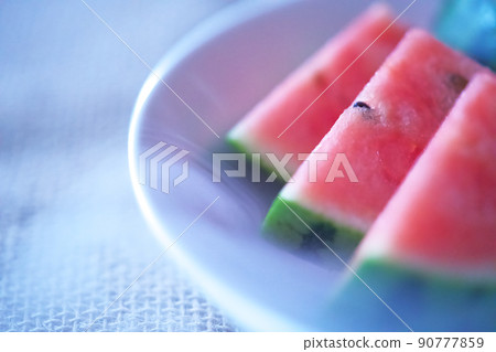 Summer image of a watermelon on a white plate that gives off cold air Summer image of a watermelon on a white plate that gives off cold air 90777859