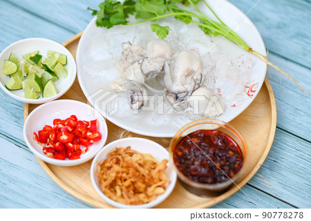 seafood plate fresh oyster on white plate background , oyster on ice with lemon lime chili sauce fried onion and seafood sauce Thai food seafood plate fresh oyster on white plate background , oyster on ice with lemon lime chili sauce fried onion and seafood sauce Thai food 90778278