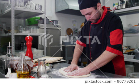 Restaurant kitchen. A chef making a dough for the pizza 90779201