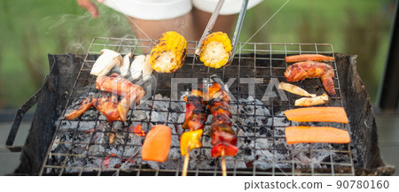 delicious grilled meat with smoke, BBQ with vegetables in outdoor. Barbecue, Party, lifestyle and picnic concept delicious grilled meat with smoke, BBQ with vegetables in outdoor. Barbecue, Party, lifestyle and picnic concept 90780160