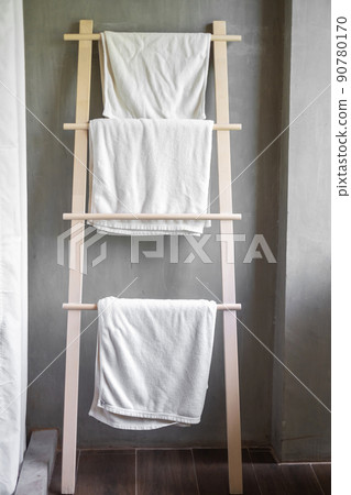 Closeup clean bathrobe and towel hanging in wooden wardrobe at luxury hotel. Relax and travel concept Closeup clean bathrobe and towel hanging in wooden wardrobe at luxury hotel. Relax and travel concept 90780170