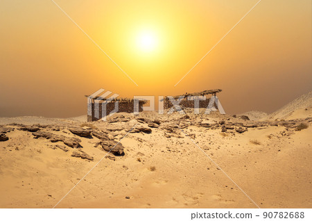 Small huts in the middle of the desert with an amazing landscape background. Desert stone hut. dust storm. 90782688