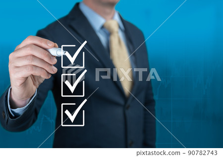 Businessman hand checking the checklist boxes on blue background. Businessman with pen mark the check boxes. Hand choosing one of three options. blue background. copy space 90782743