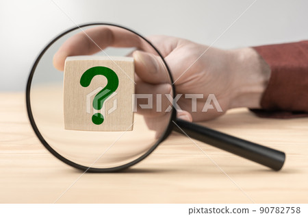 Man hand holding question mark in front of magnifying glass. Search for an answer to question. Research, searching or investigating something. search for solution to problem 90782758