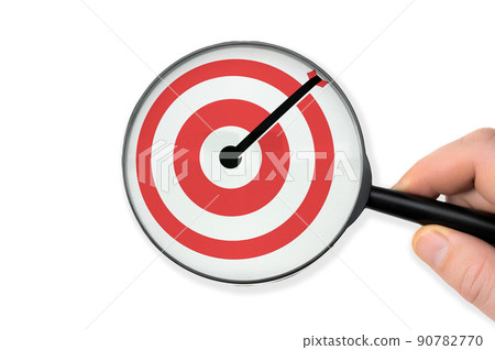Target board inside of magnifier glass for focus business objective on white background and copy space. Hand with magnifying glass holds its hand over target. business goal concept on white 90782770