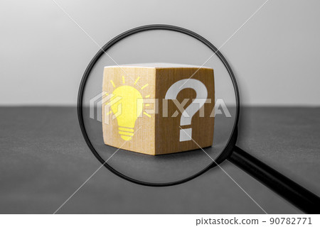 Magnifying glass with light bulb icon and question mark symbol. Concept creative idea and innovation. Magnifying glass with question mark and lightbulb in focus on wooden cube. 90782771