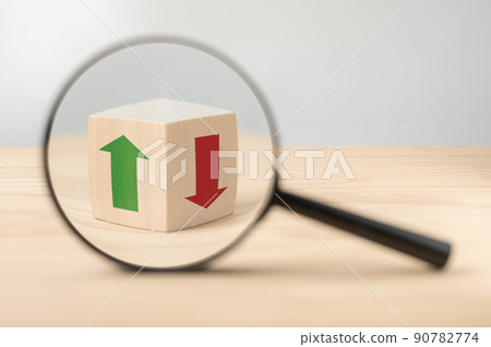economic growth and decline analysis. Magnifying glass and wooden cube with green and red arrow. Business analysis concept, dynamics of growth and decline of indicators. Searching of decisions economic growth and decline analysis. Magnifying glass and wooden cube with green and red arrow. Business analysis concept, dynamics of growth and decline of indicators. Searching of decisions 90782774